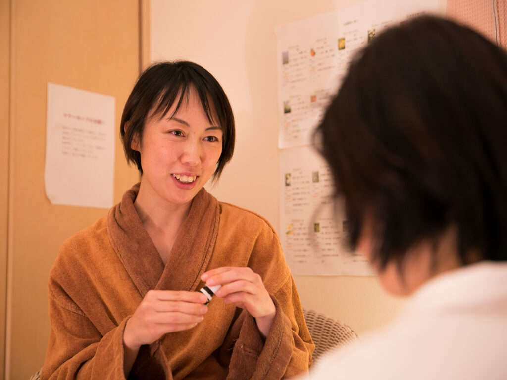 精油の効能と照らし合わせながら香りを嗅いでカウンセリングを行う様子